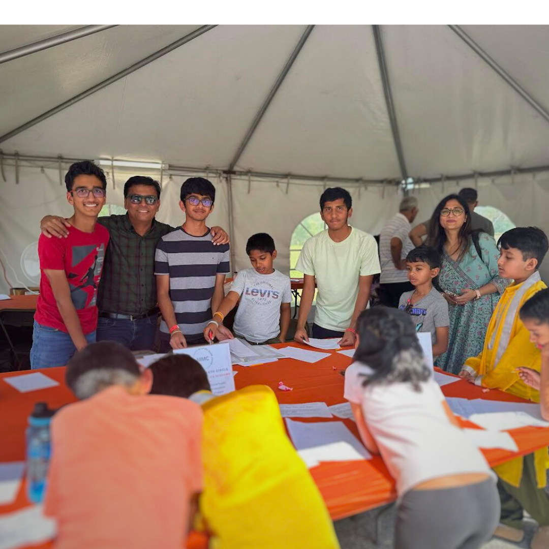 Students and families working on math activities around a table at IndiaFest